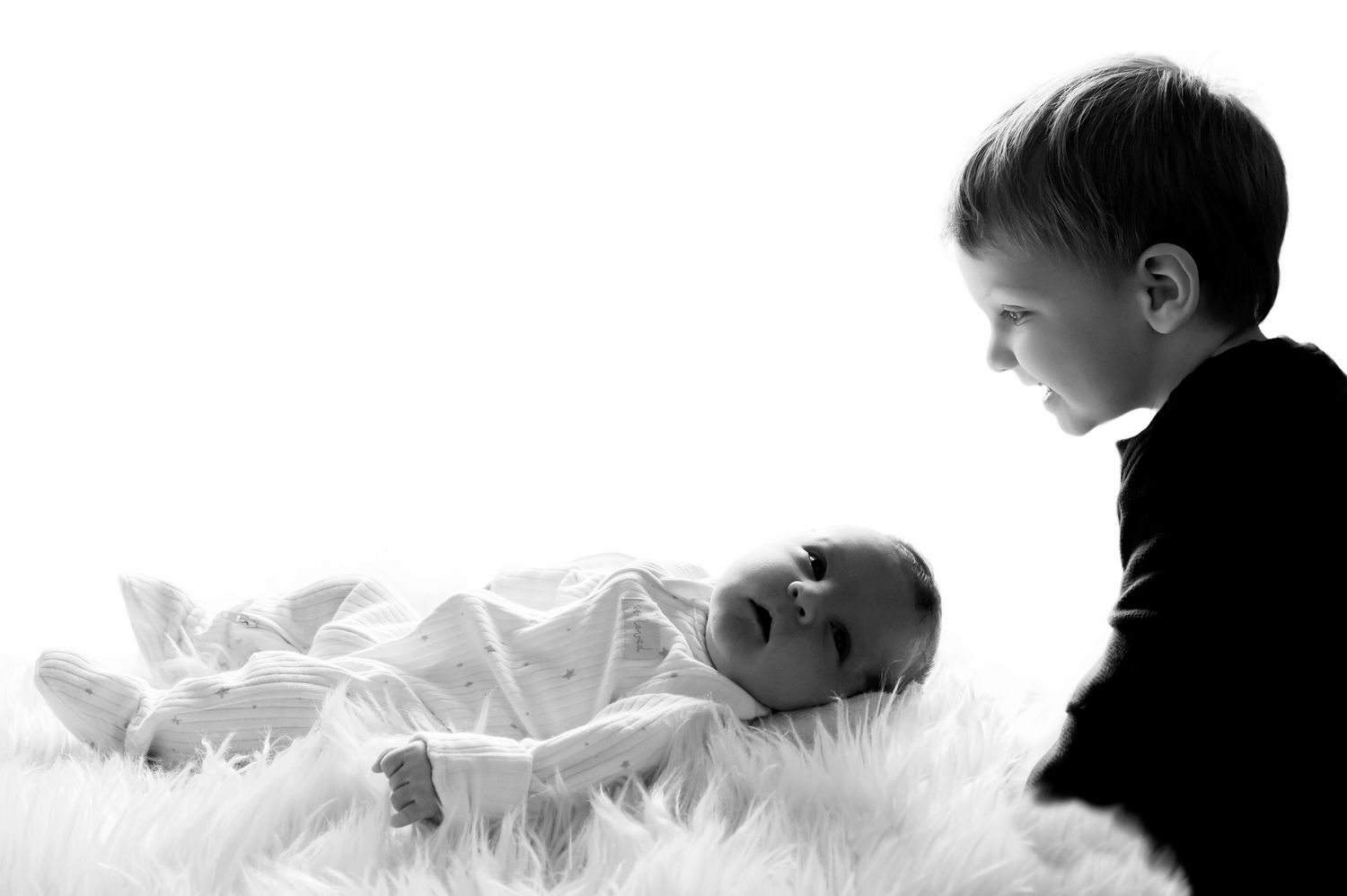 Multiple views of a baby crawling and playing in white fabric against a black background.