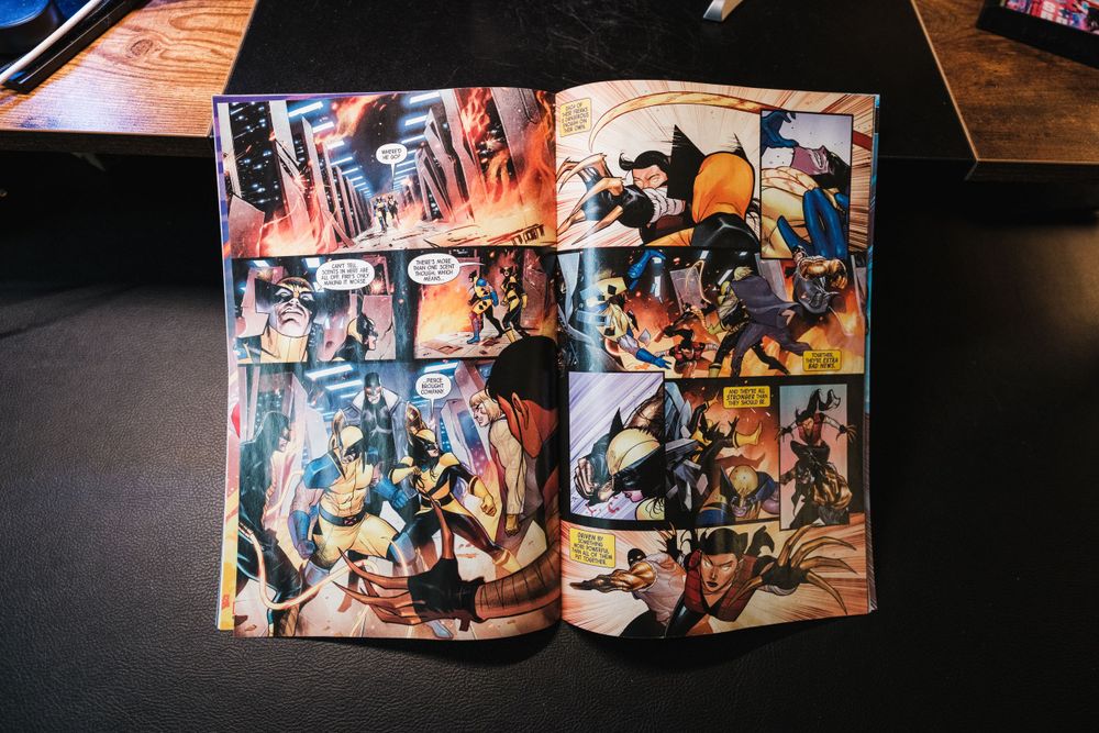 Open manga comic book showing colorful action scenes and dynamic illustrations spread across two pages.