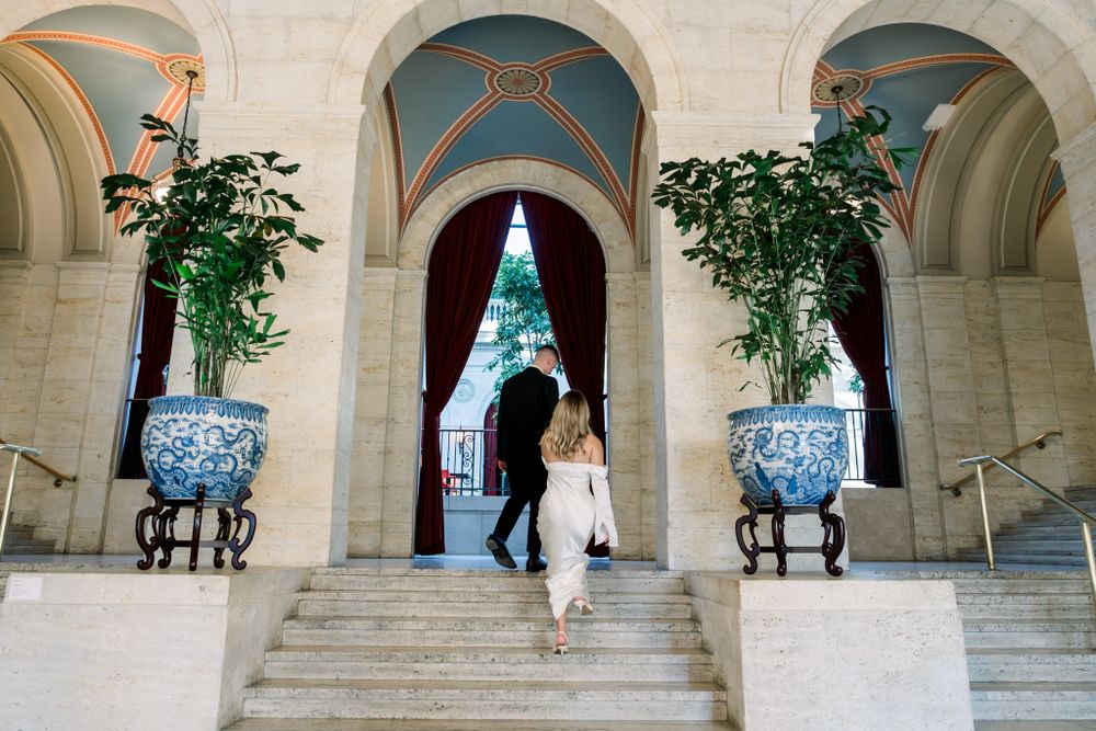 Elegant archway entrance with blue and white vases and potted plants framing marble steps.