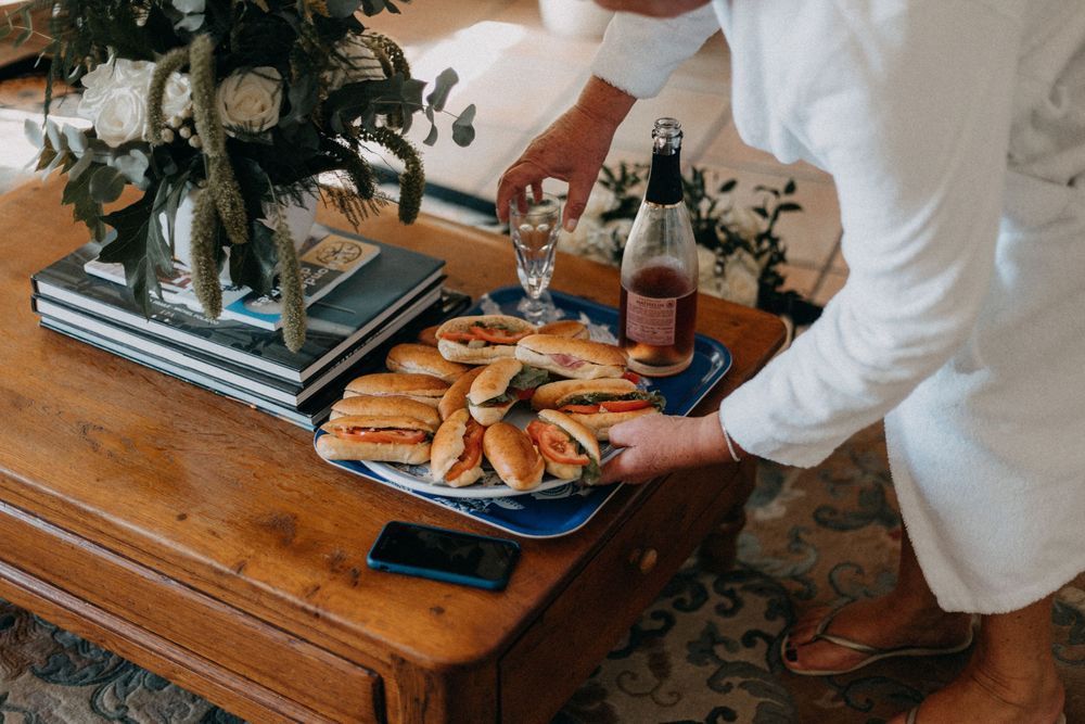 Platter of appetizers and wine being served on rustic wooden table.