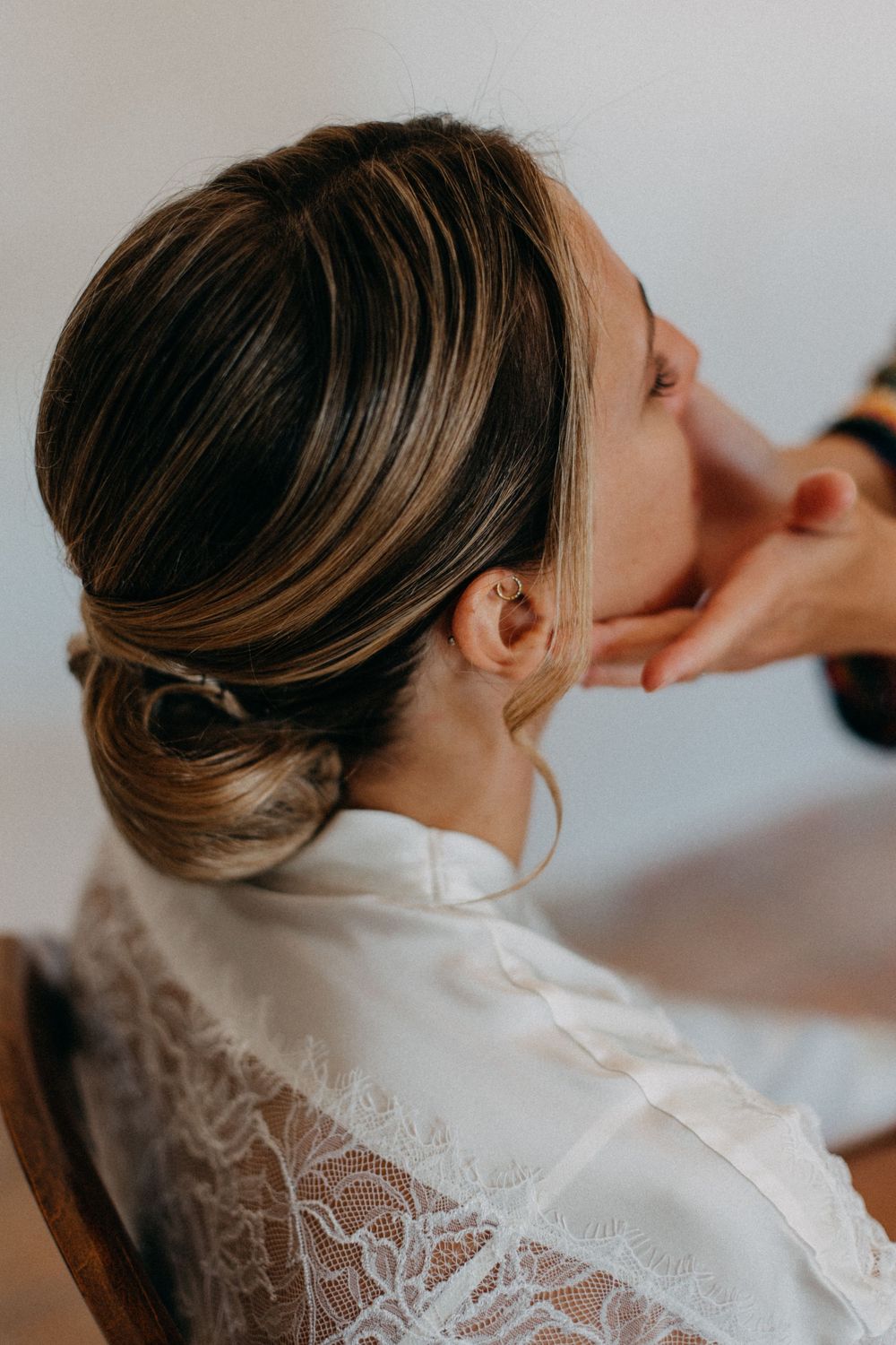 Close-up of elegant bridal hairstyle with classic updo in natural light.