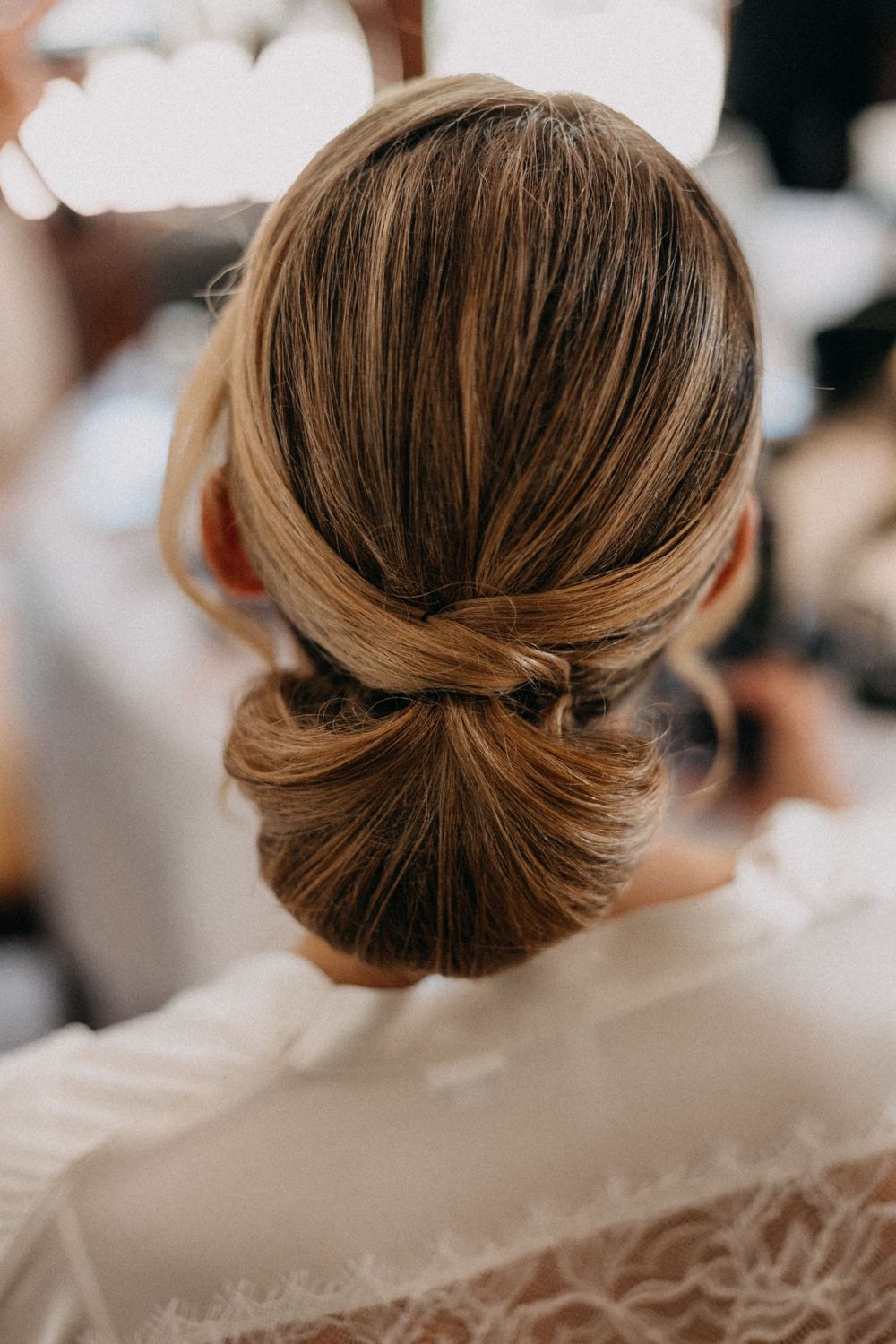 Elegant bridal updo hairstyle with twisted detail and low chignon bun styled for a wedding.