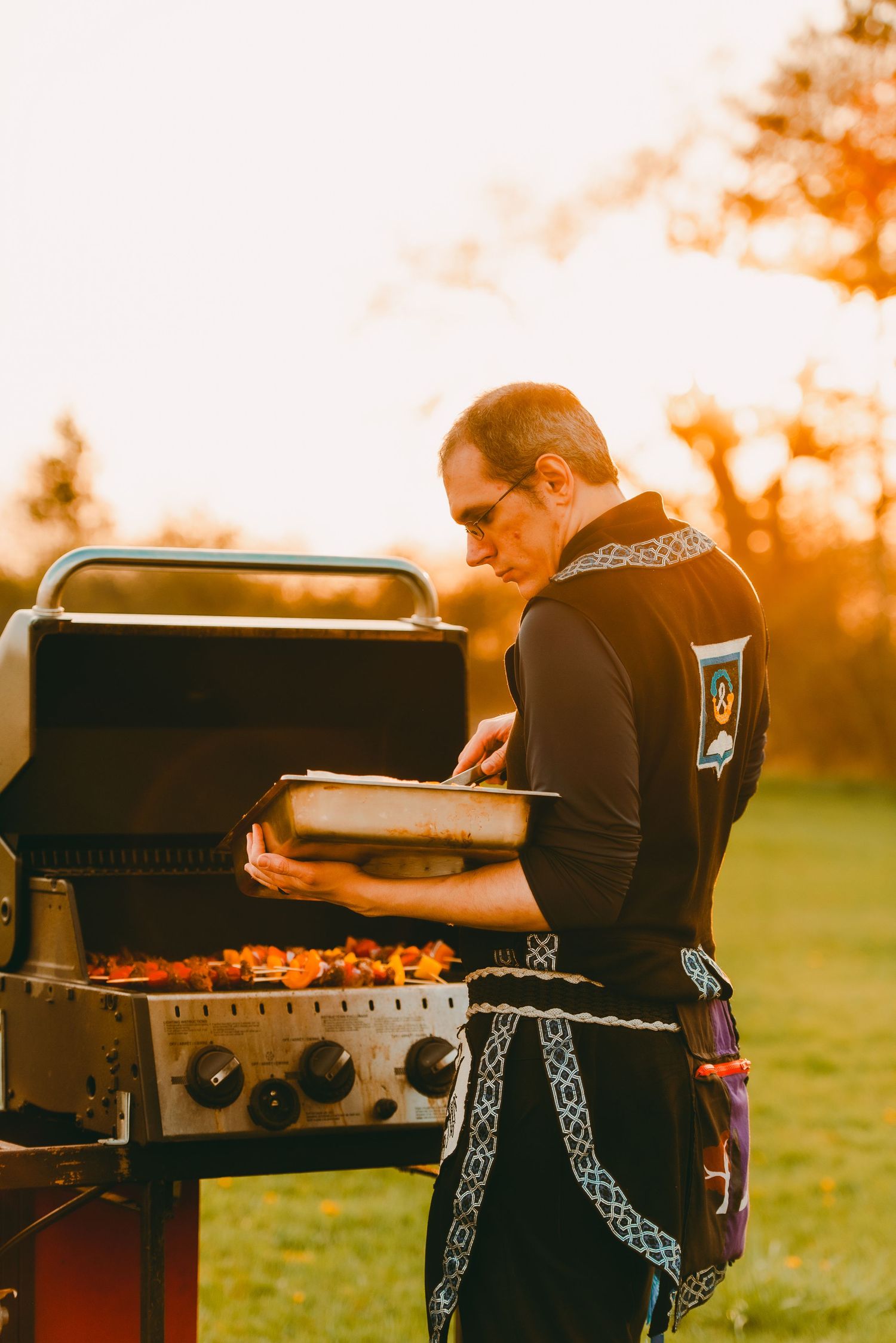 Man cooking on BBQ at sunset