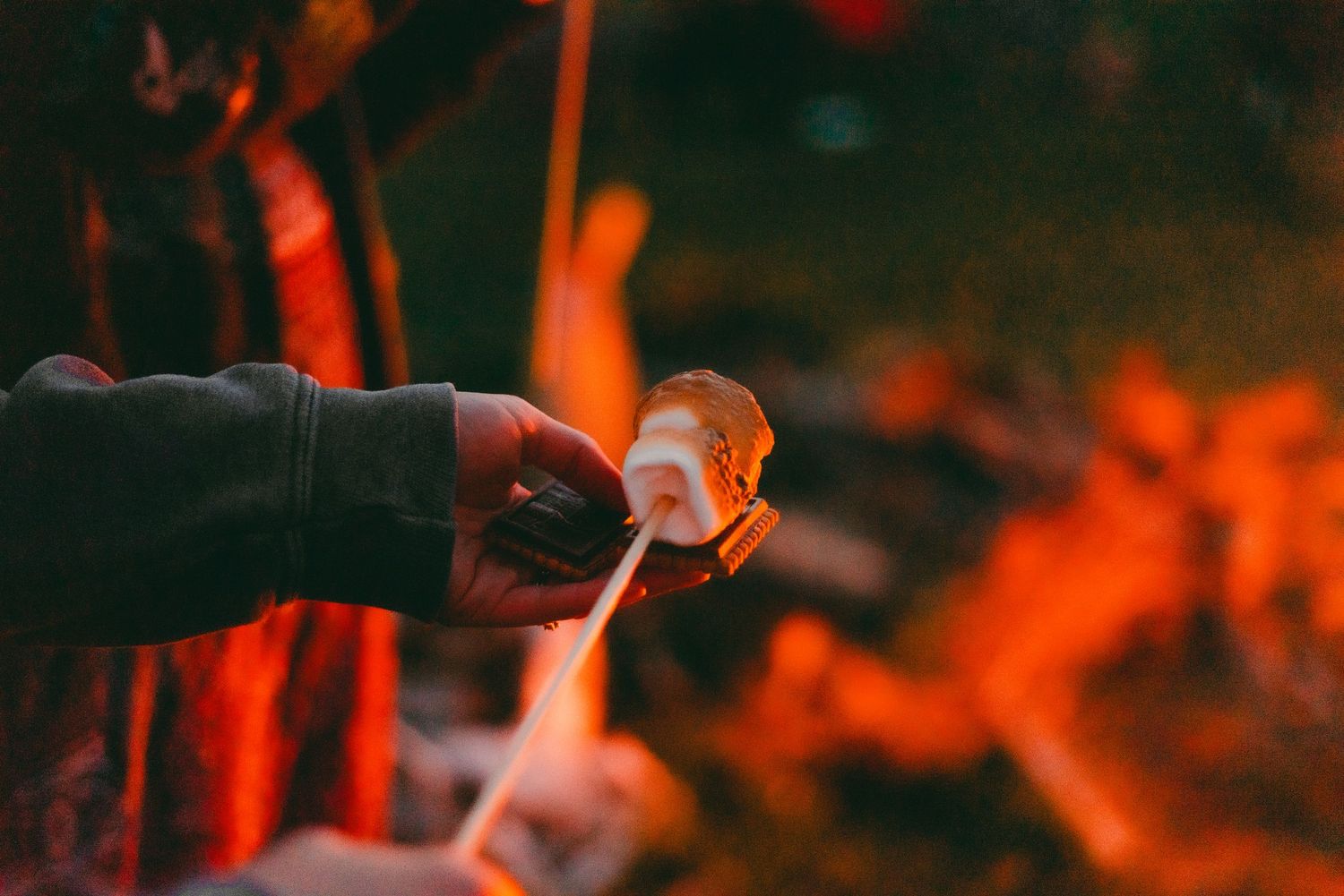 Person making a smore around a campfire