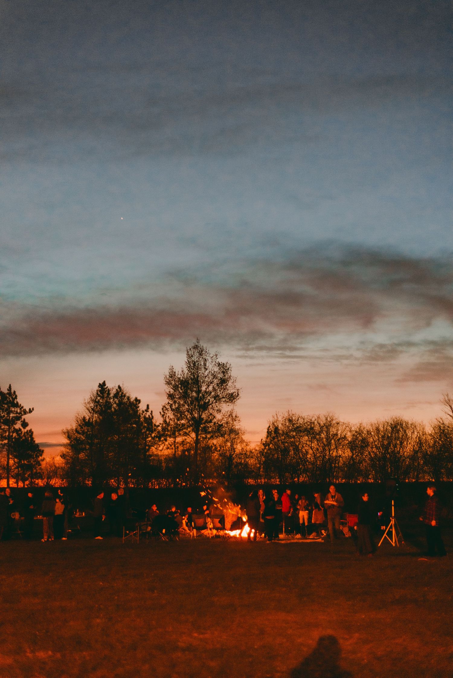 Community campfire wedding reception at sunset
