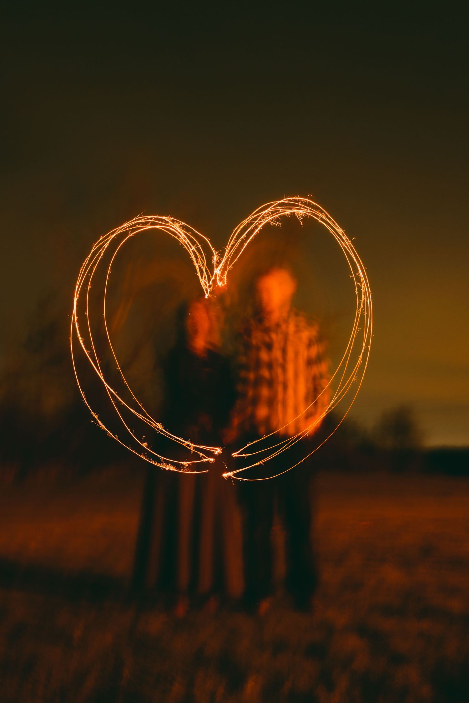 Couple draw a heart around themselves with long exposure sparker photo
