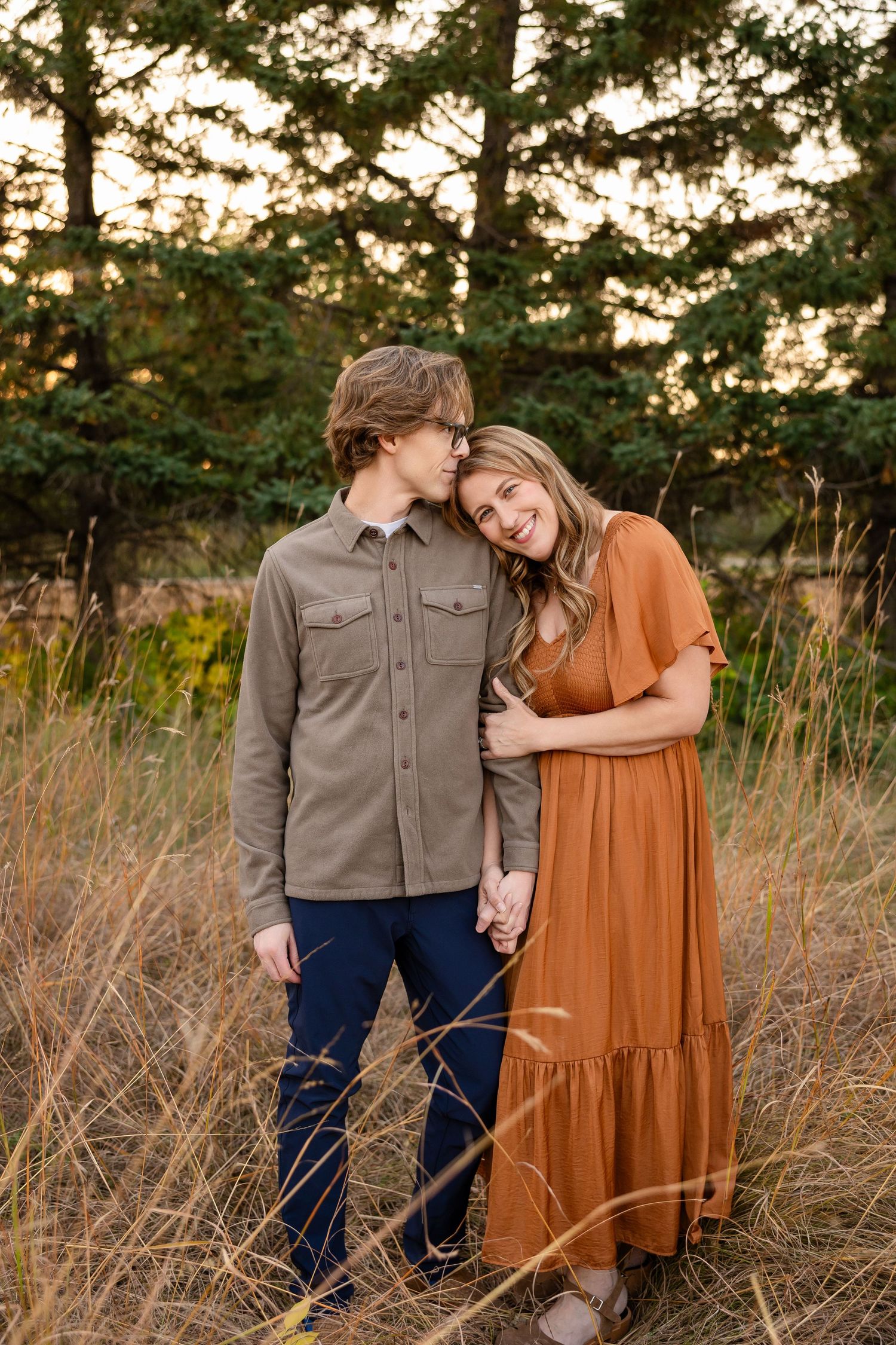 Family enjoying an autumn photo session outdoors with colorful fall foliage in the background.