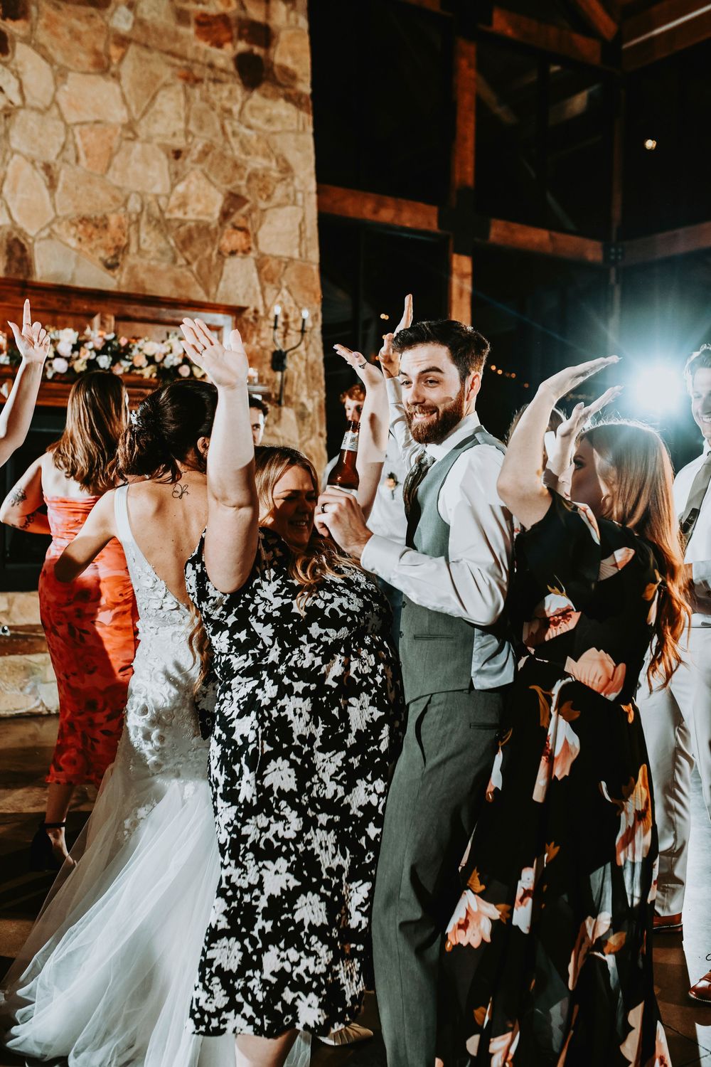 Bridesmaids and groomsmen laughing and dancing during the reception, mint green dresses twirling.