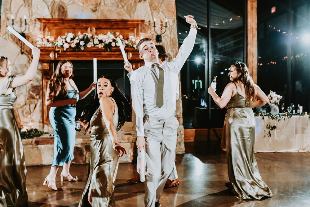 Wedding party dancing with glow sticks and signature cocktails, bringing the ultimate party vibes.