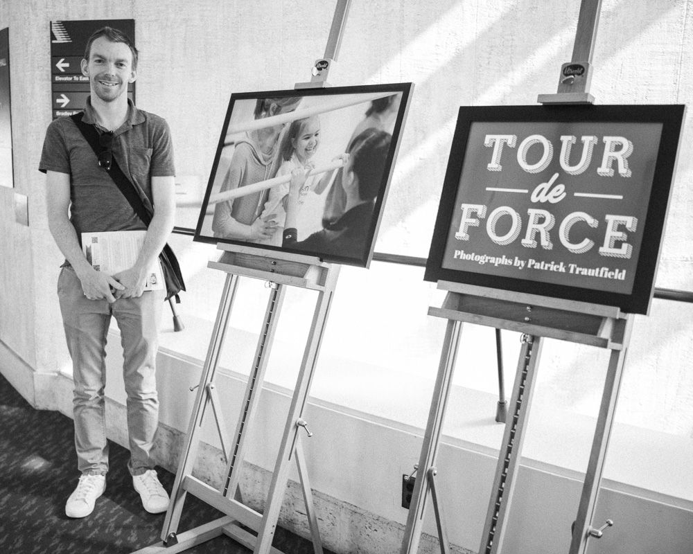 Art exhibition display with multiple framed photographs and a 'Tour De Force' sign.