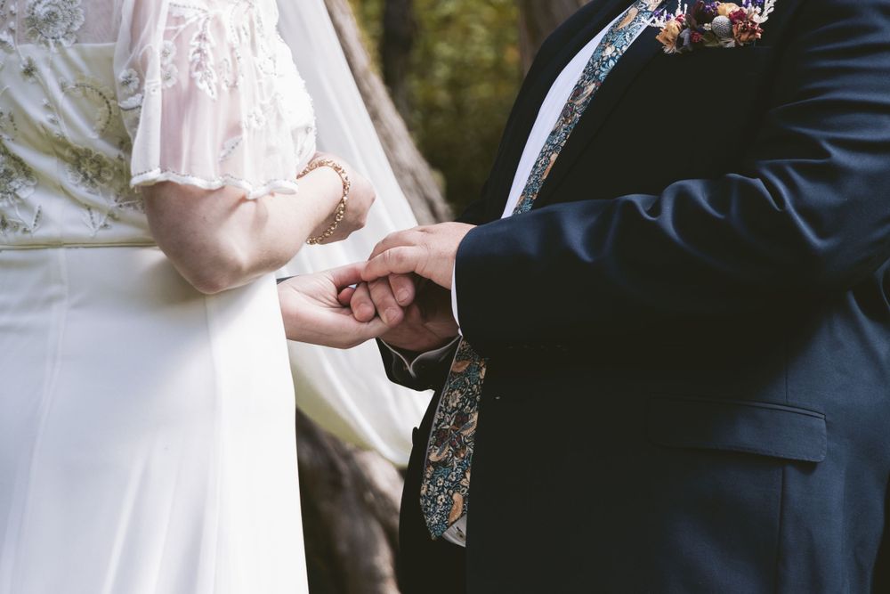 Close-up shot of hands exchanging rings during a wedding ceremony.
