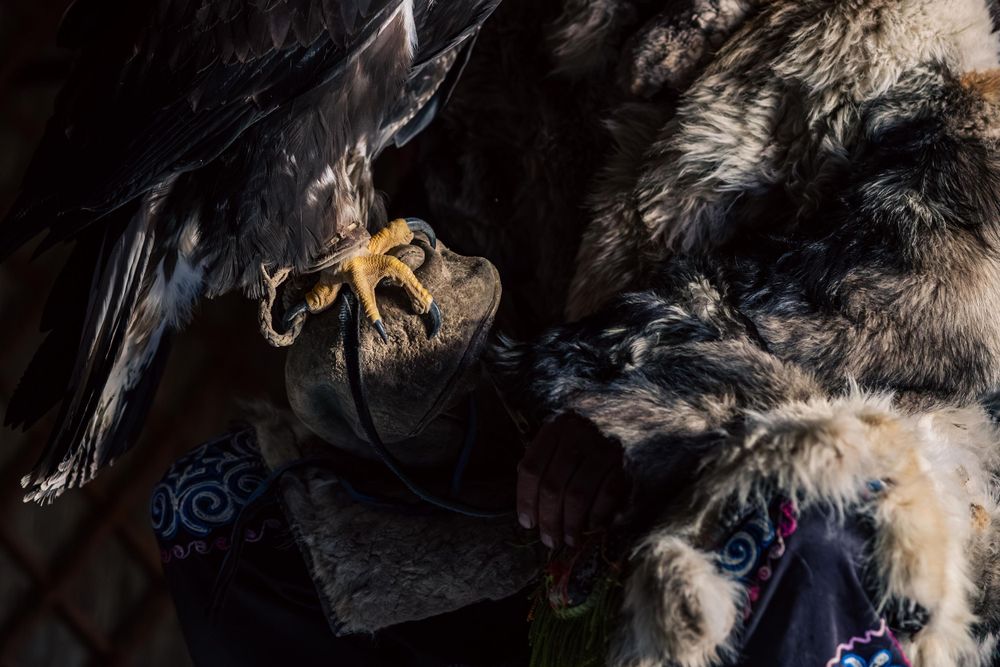 Dark atmospheric still life showing traditional hunting equipment and cultural artifacts.