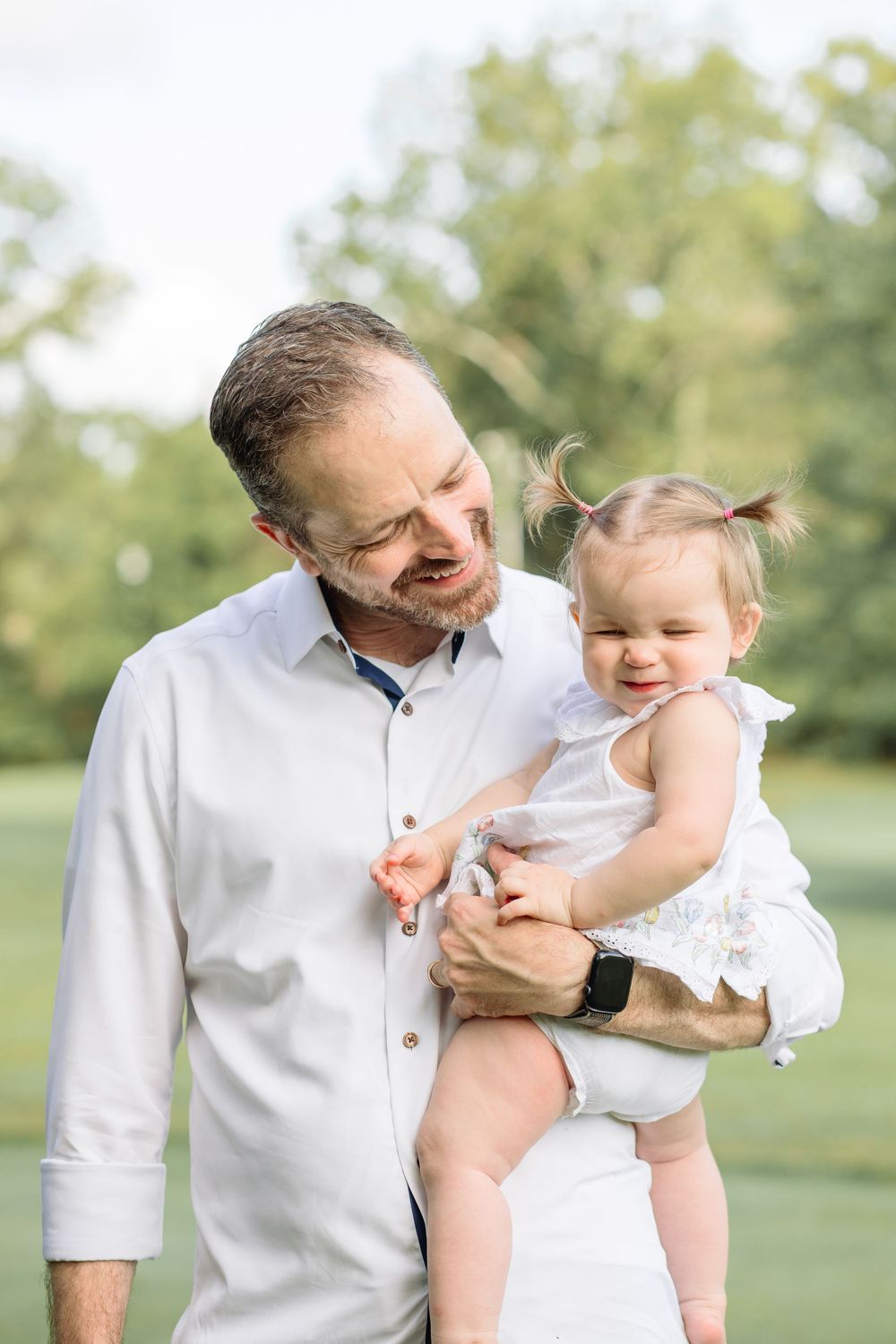 A tender moment captured between parent and child outdoors in natural lighting.