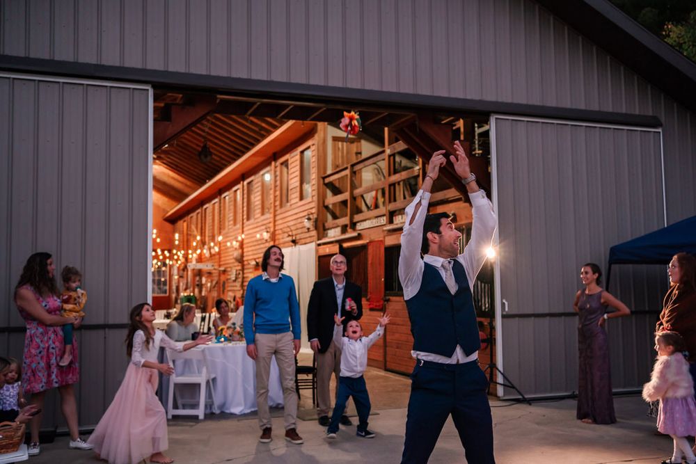 A groom does the bouquet toss at the end of the wedding night.