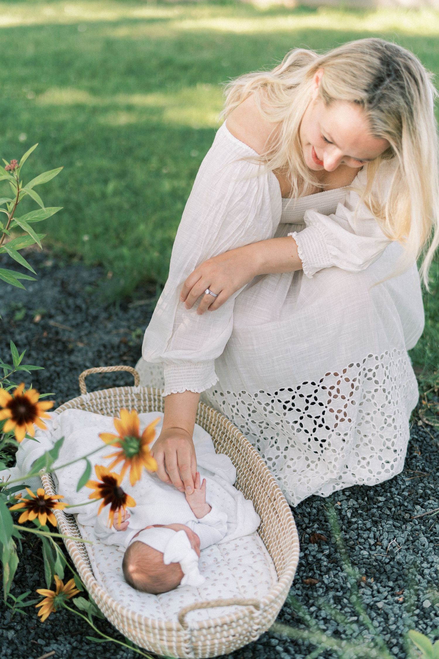 A peaceful outdoor scene with sunflowers where a baby rests in a woven bassinet.