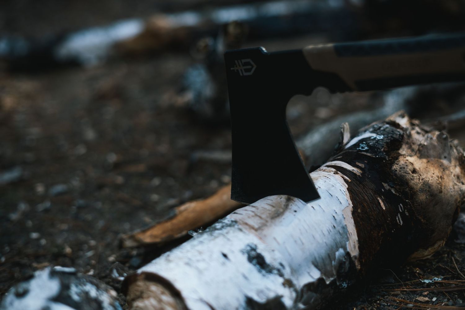 Gerber hatchet embedded in a wooden log, showcasing its durability and rugged design for outdoor use.