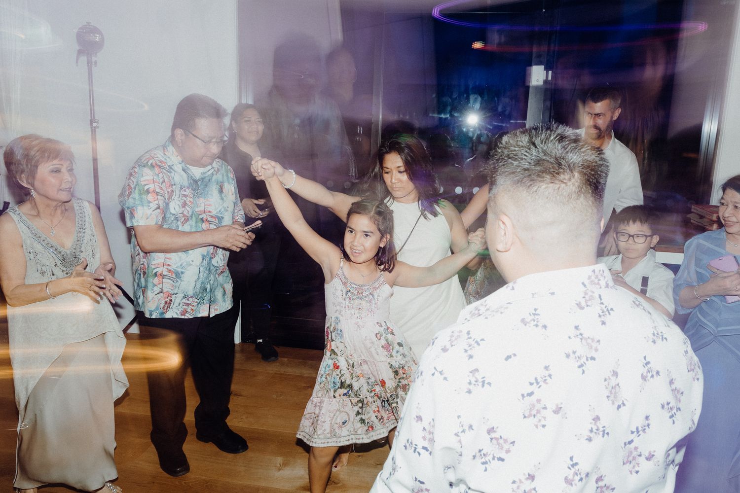 People dancing at a celebration event with motion blur captured by Apertured Media Auckland Wedding Photographer.
