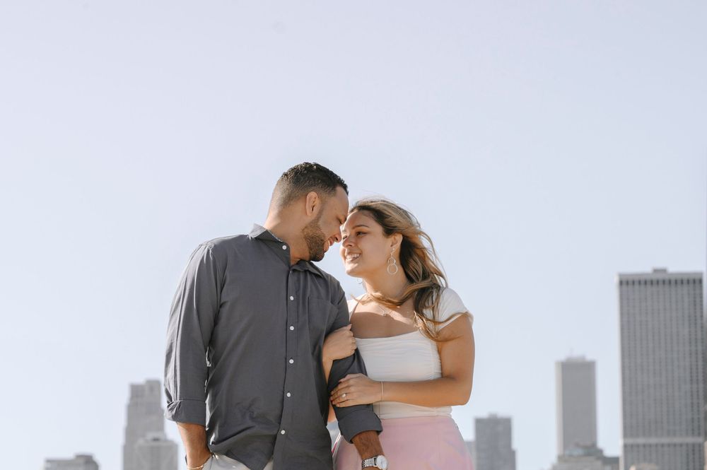 A romantic couple sharing an intimate moment against a city skyline background.