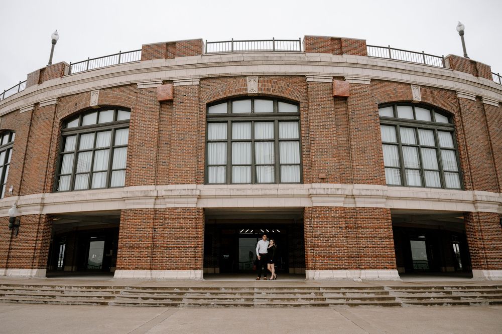 Exterior view of a classic brick stadium building with arched windows and columns.