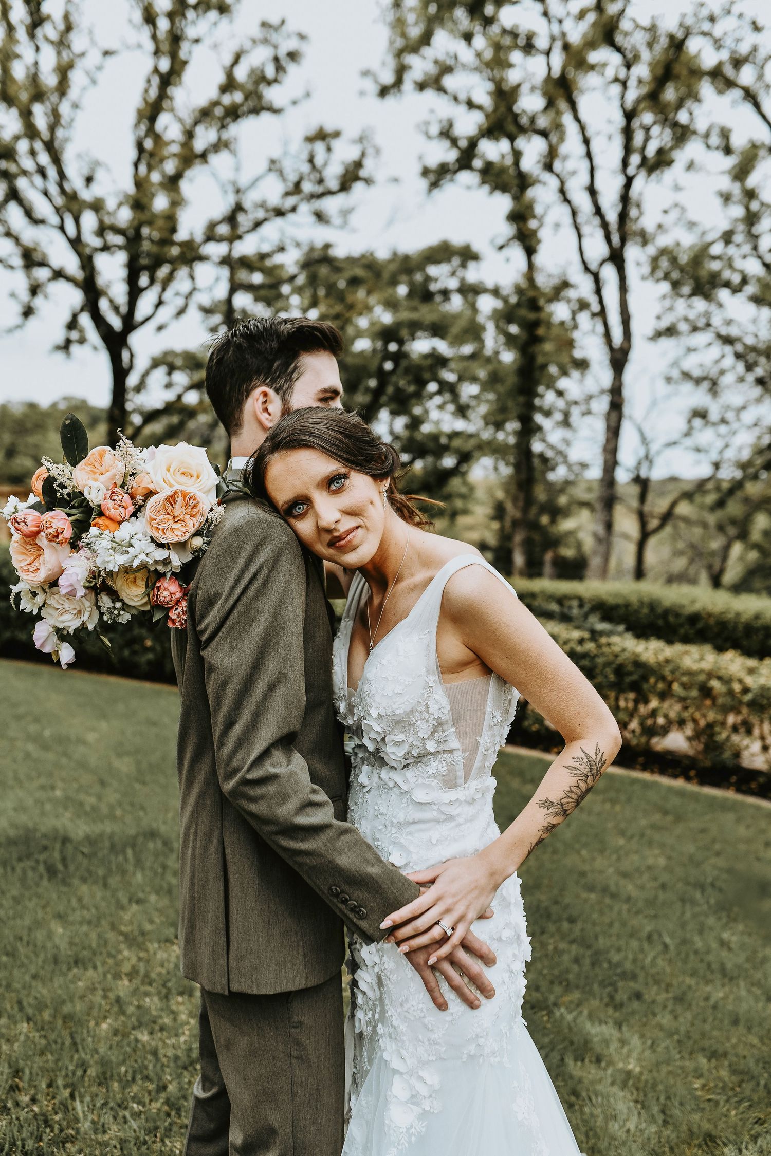 Bride and groom laughing while walking through the lush grounds at The Lodge at The Springs, with the iconic stone building in the backgroun