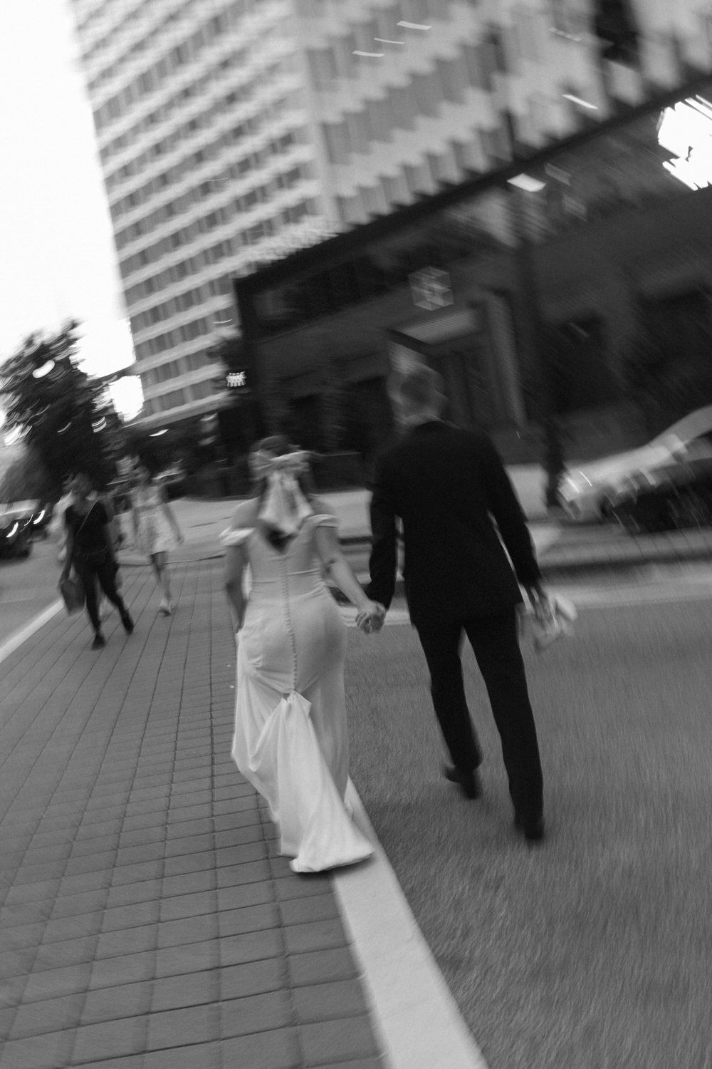 a blurry black and white photo of a bride and groom crossing the street on their atlanta city elopement day