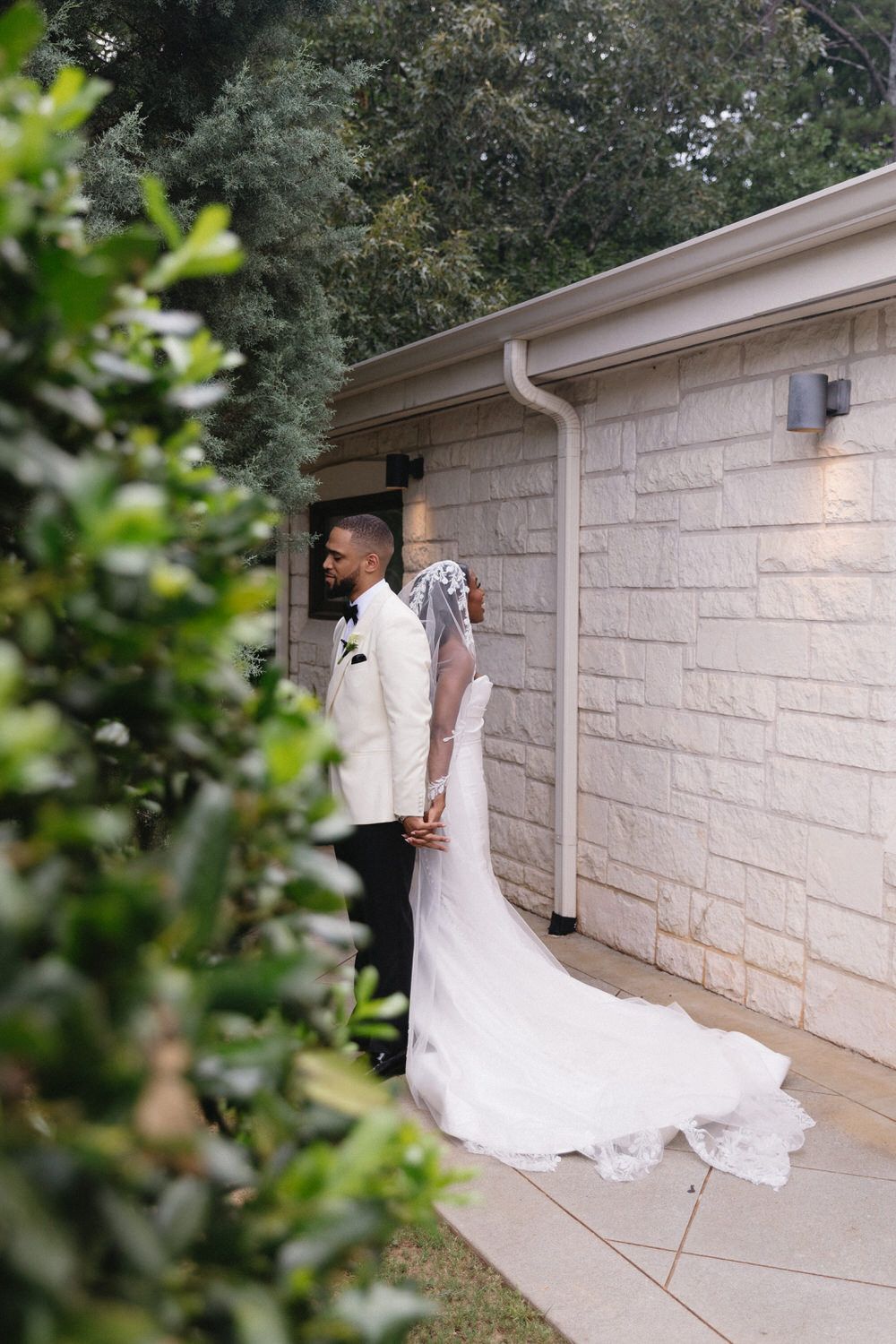 A bride and groom standing together in elegant white attire outside ashven estate on their intimate wedding day.