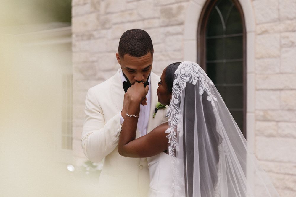 An emotional moment captured as a groom in a white suit and tie wipes the brides tears during an outdoor elopement ceremony in denver