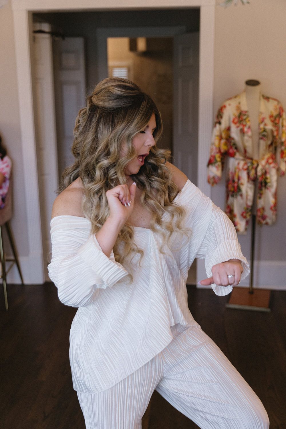 a bride dances in her white pajamas before getting ready for her intimate wedding day