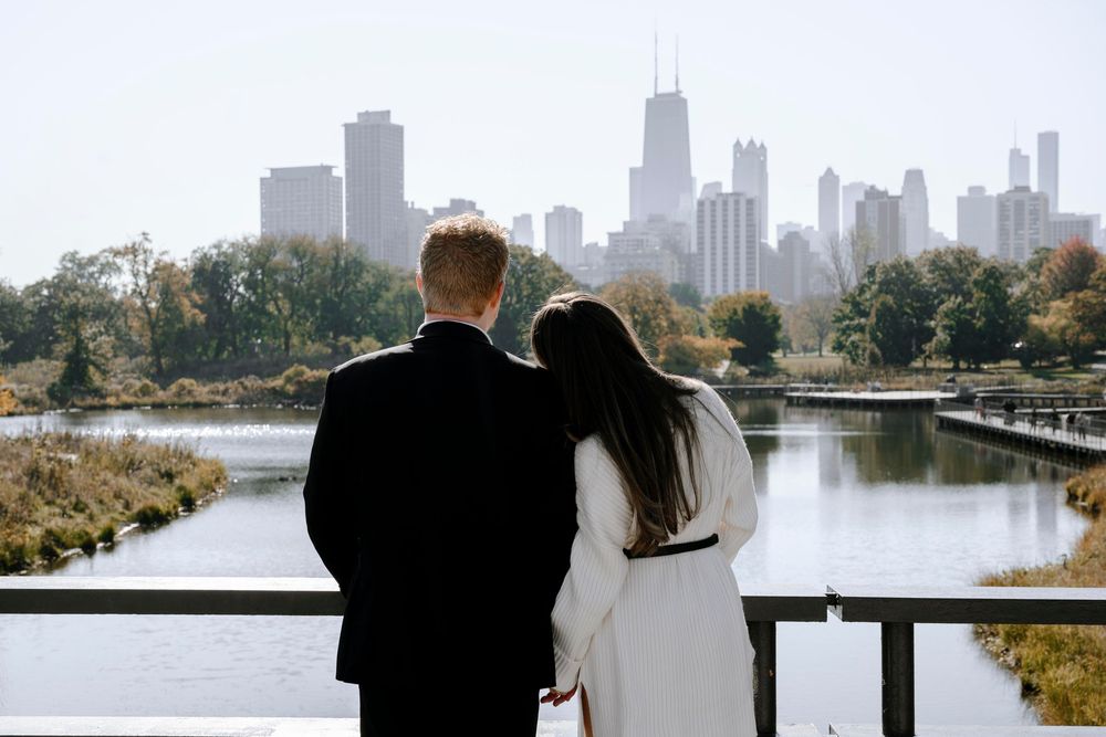 Couple overlooking Chicago skyline from Lincoln Park in autumn with lake and skyscrapers in background.