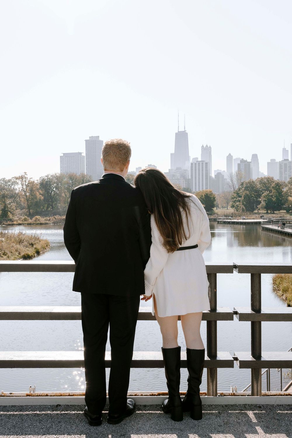 Couple admiring Chicago skyline from lakefront viewing spot on autumn afternoon.