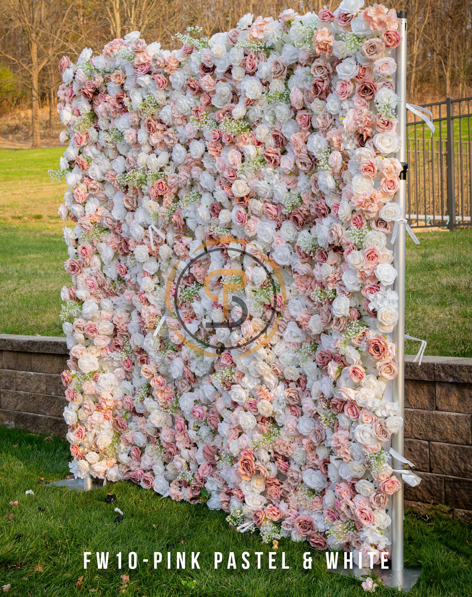 Romantic pink and white floral wall backdrop with delicate roses and centered monogram.