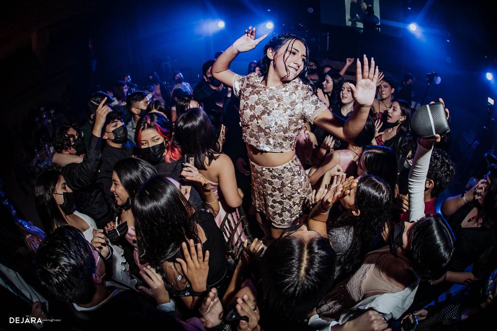 Lively nightclub crowd during a party with blue stage lighting.