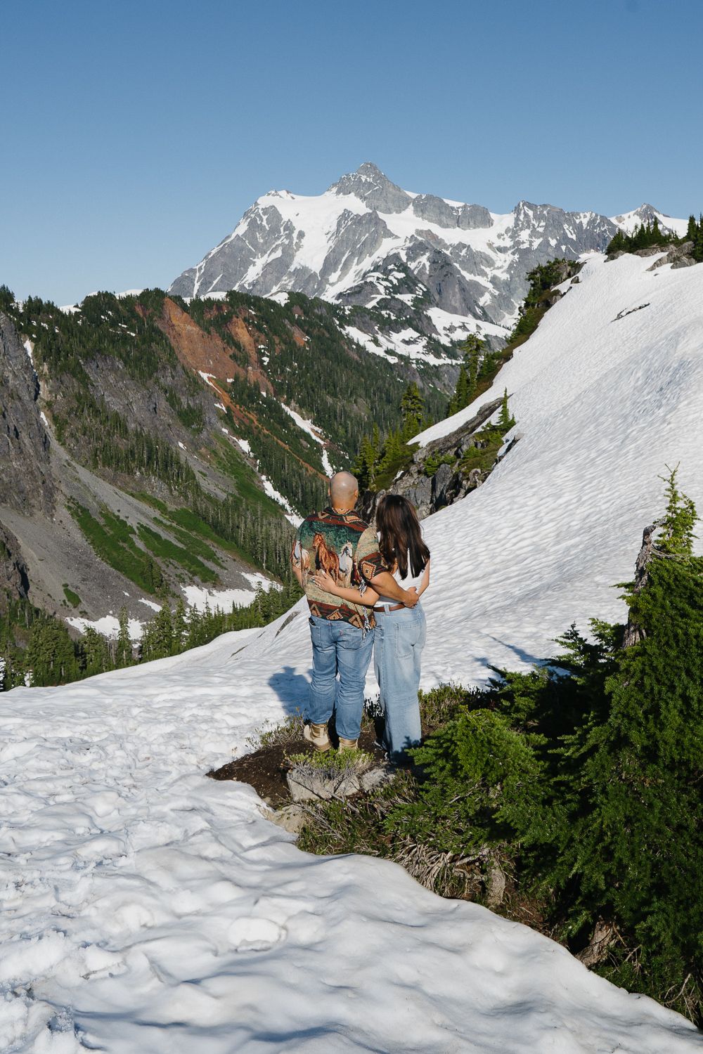 A scenic sequence of snowy mountain views shows hikers on a trail overlooking snow-covered peaks in summer.