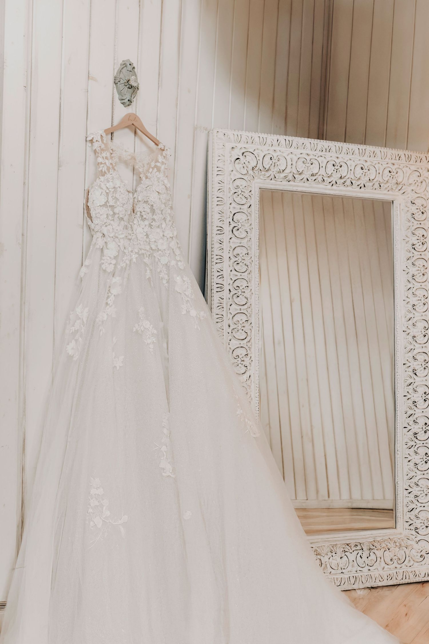 Long train of the gown draping from a wooden beam, ready for the big day
