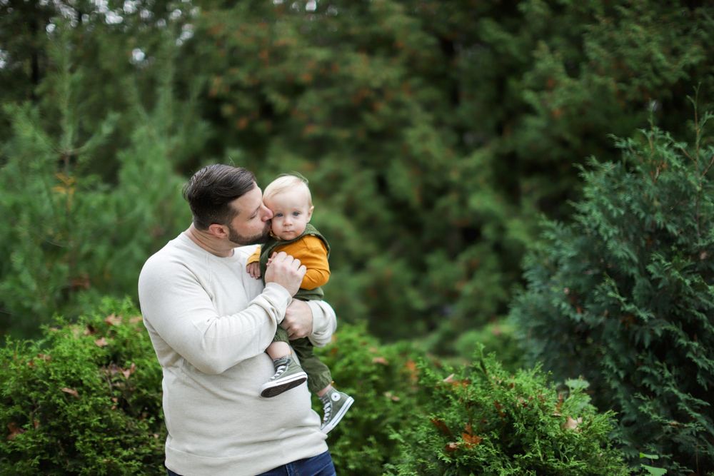 Candid family moments captured in a series of connected photos showing tender interactions in a lush outdoor setting.