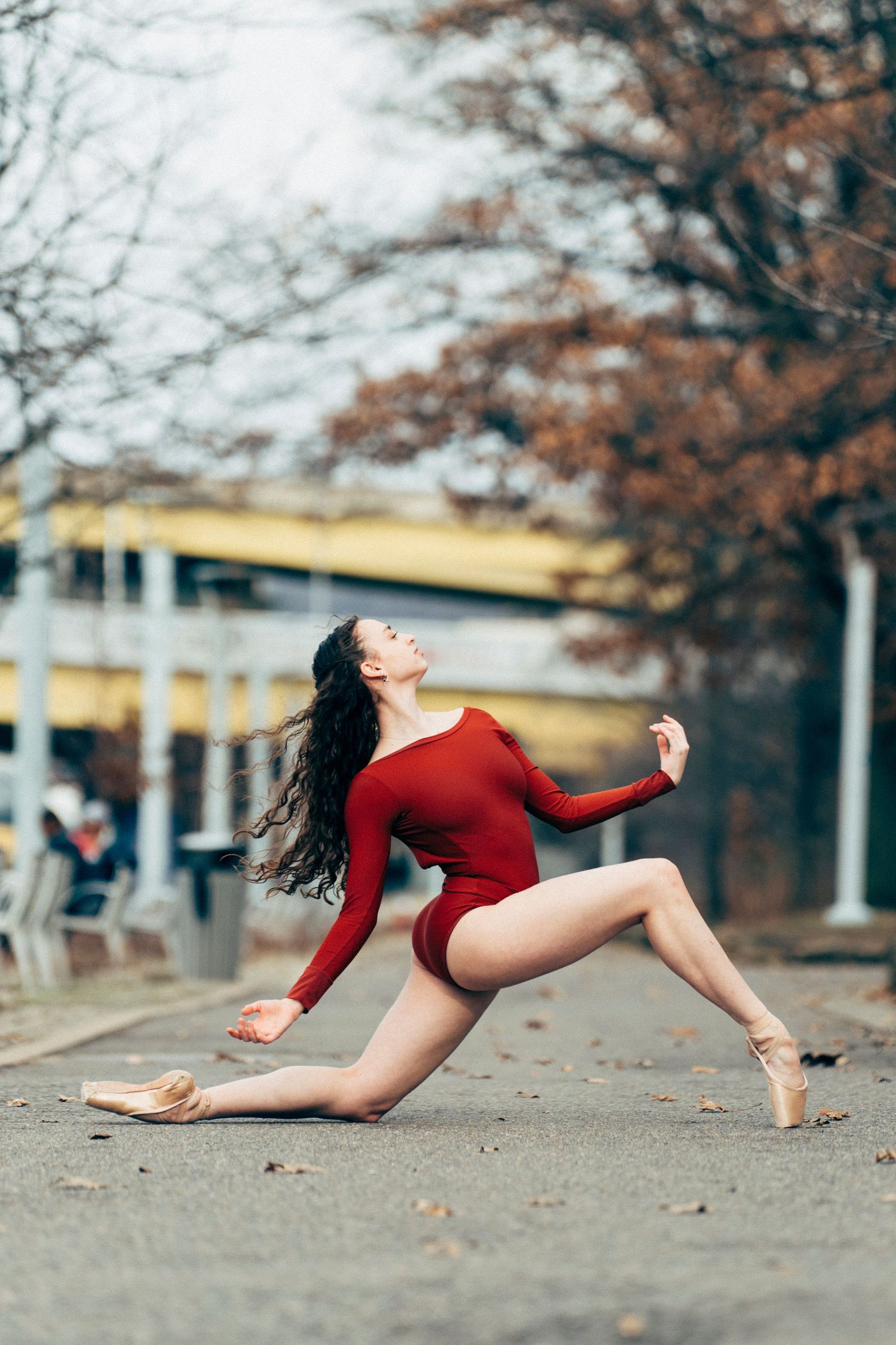Professional ballet dancer framed by sunlit trees and river views at Point State Park in Pittsburgh dance photography