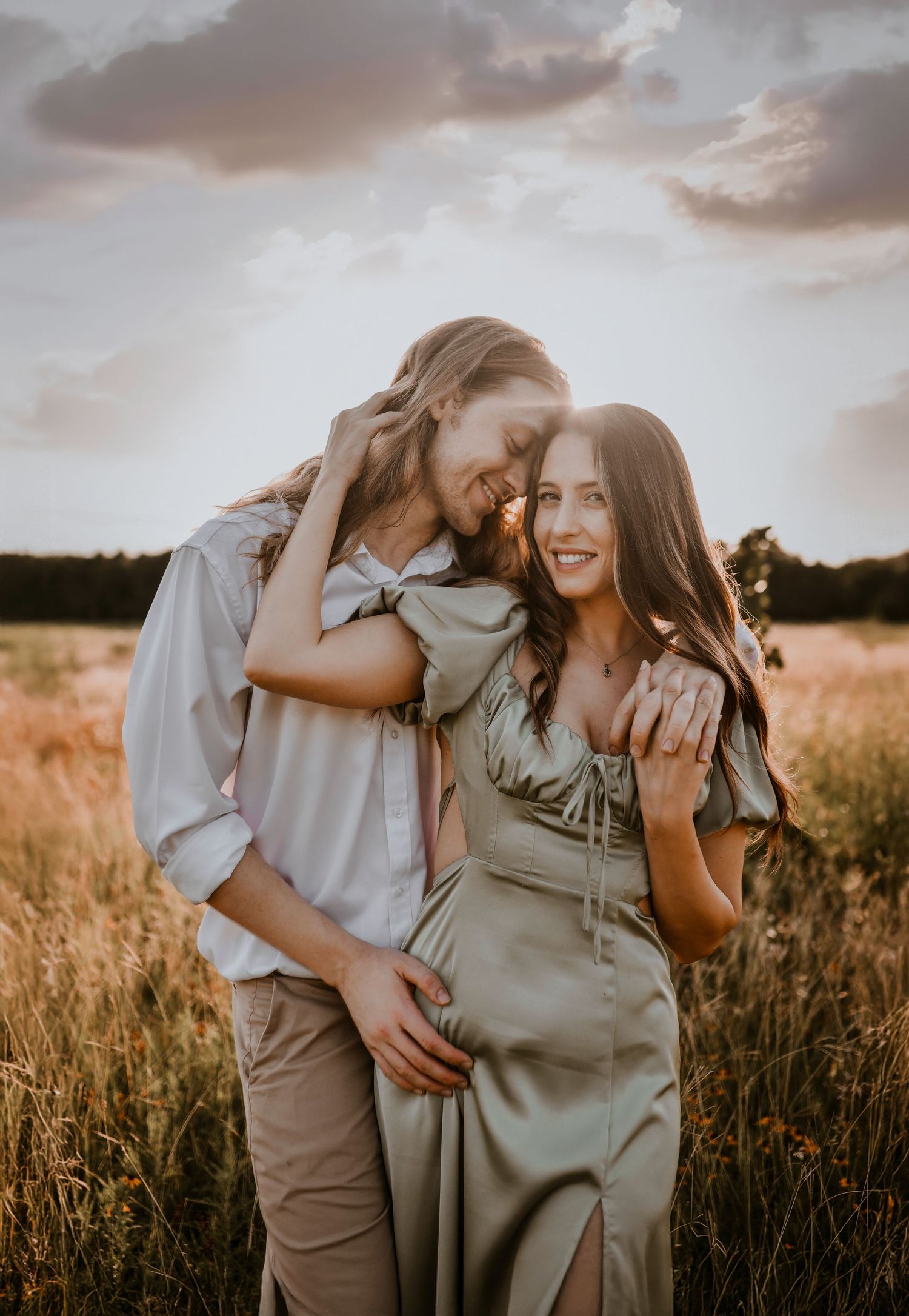 Dreamy engagement photo of couple standing in a breeze-blown landscape