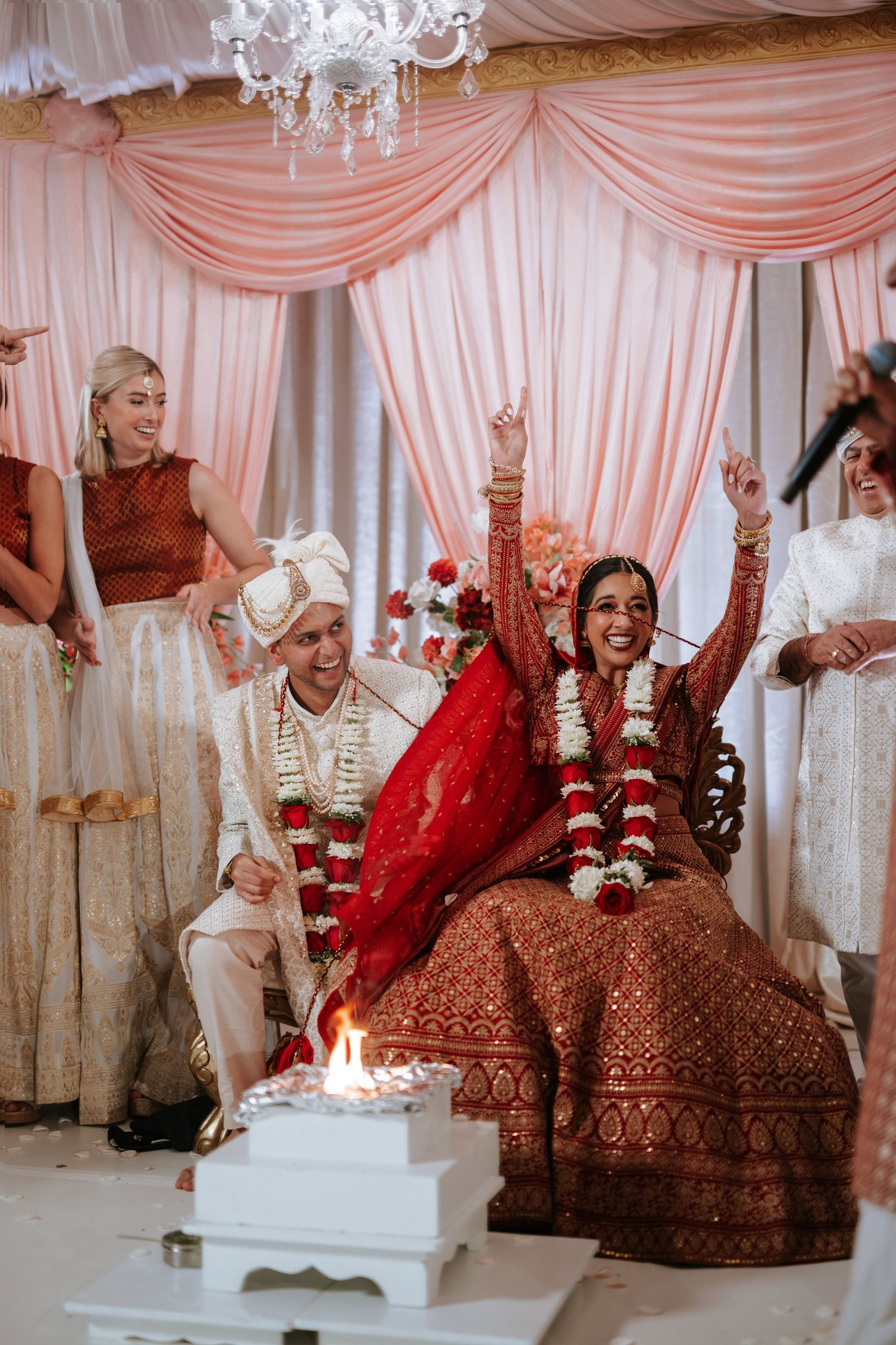 South Asian wedding at the Downtown Marriott Philadelphia, bride and groom raise hands in celebration during the ceremony.