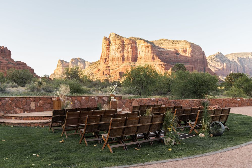 Wooden benches arranged on a lawn facing majestic red rock at sunset in Sedona, Arizona. Wedding at Red Agave Resort.