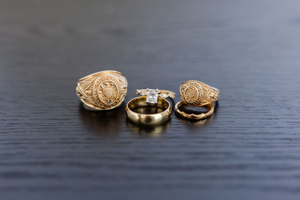 Three vintage-style gold rings displayed on a dark wooden surface.