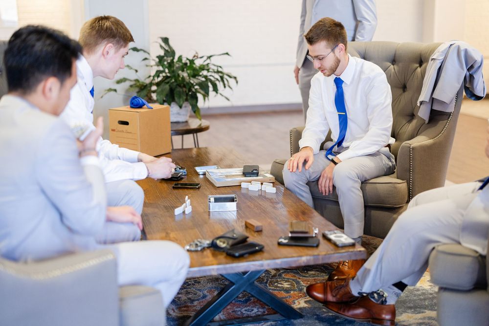 A casual gathering of people playing board games and socializing in a modern living room setting.