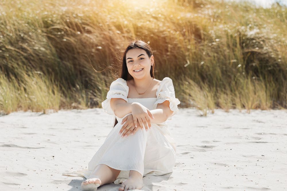 A romantic beach engagement photoshoot along a sandy shore at sunset.