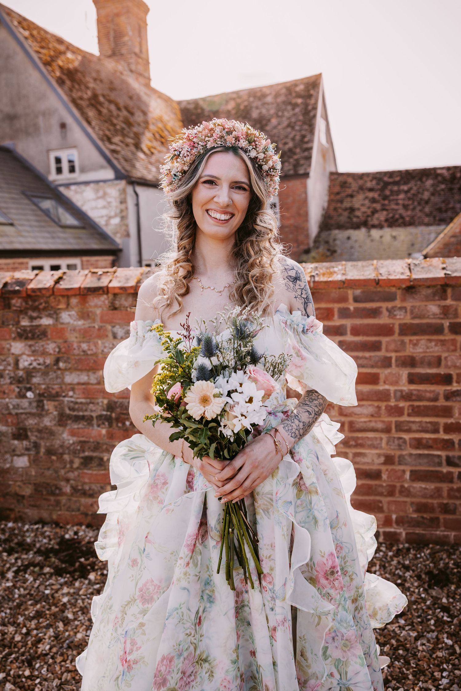A romantic wedding portrait featuring a delicate floral gown and natural flower crown against vintage architecture.