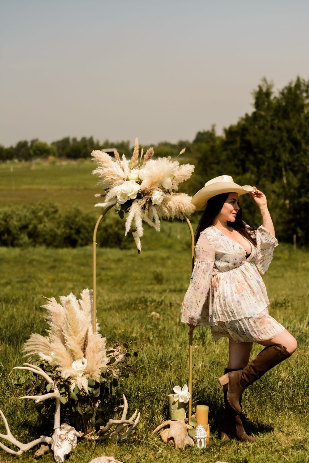 A rustic outdoor scene with pampas grass arrangements and vintage decor in a lush green meadow.