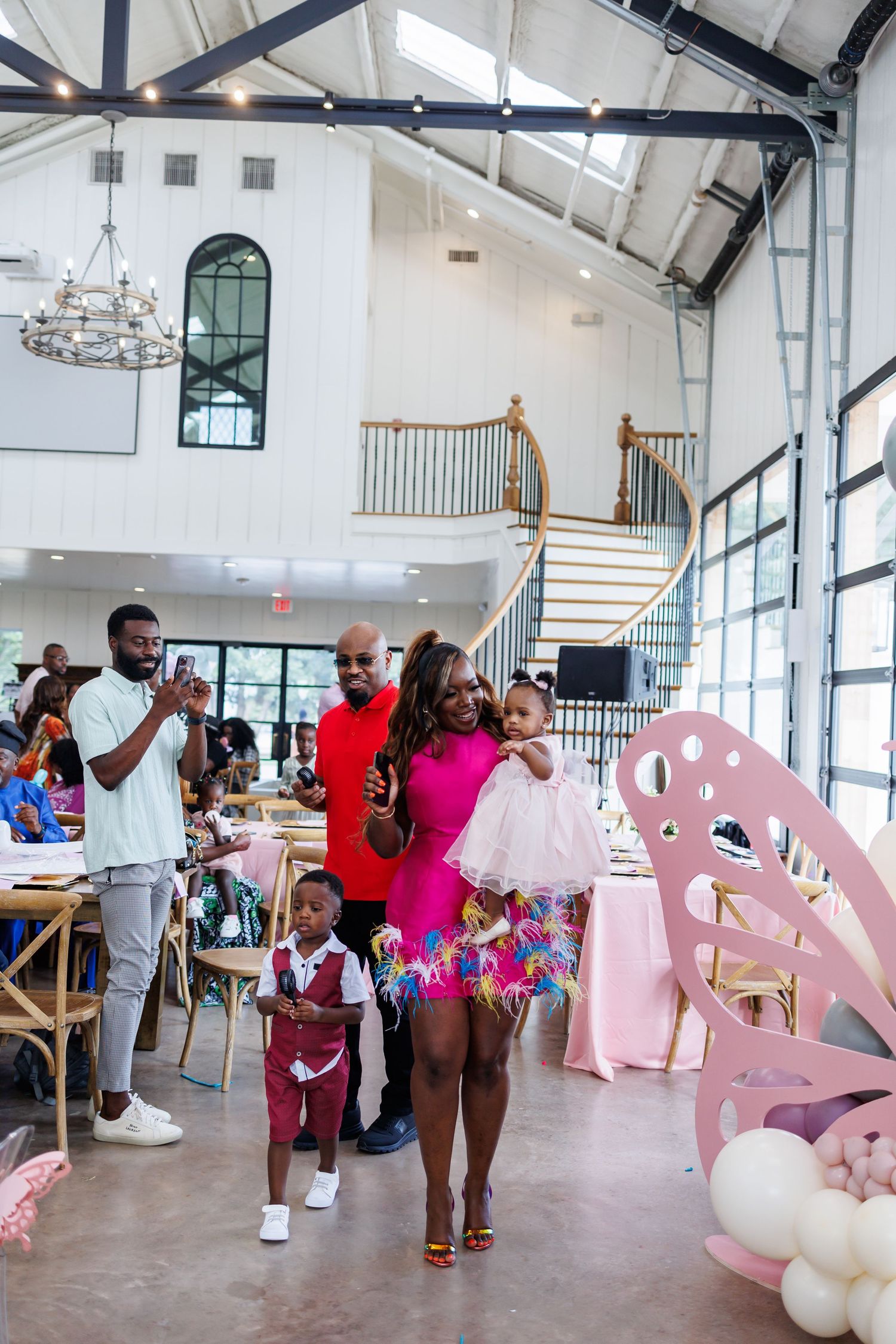 People gather at Bella Cavalli decorated with pink butterfly decorations for a little girl's first birthday party