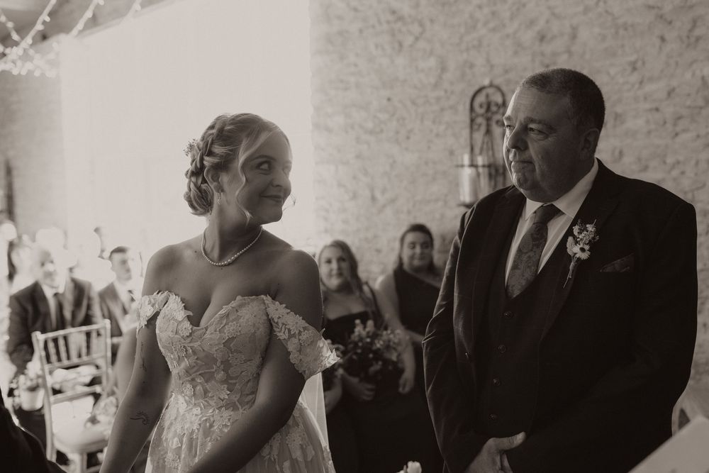 Black and white candid wedding moment during an indoor ceremony.