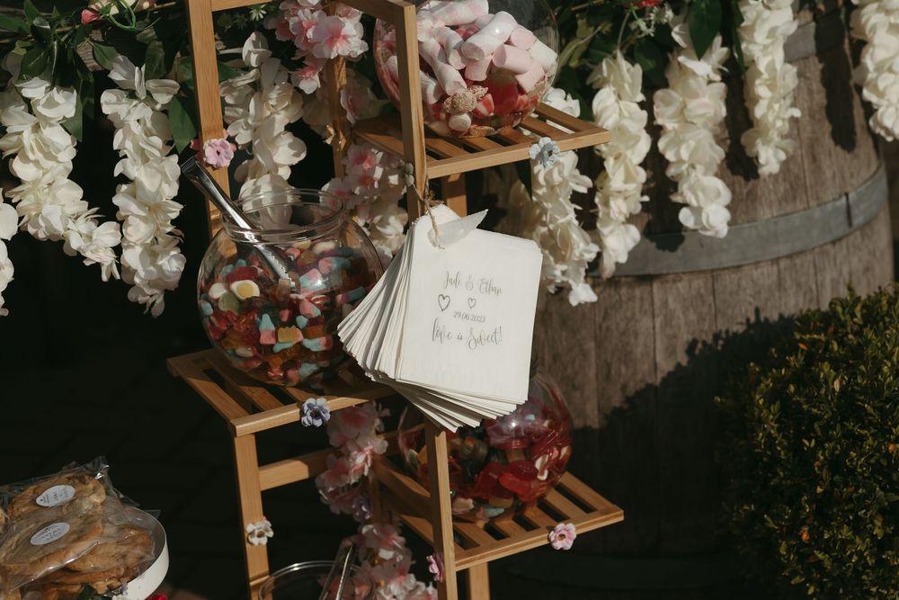 Wedding stationery displayed on a wooden ladder with white floral decorations and rustic decor.