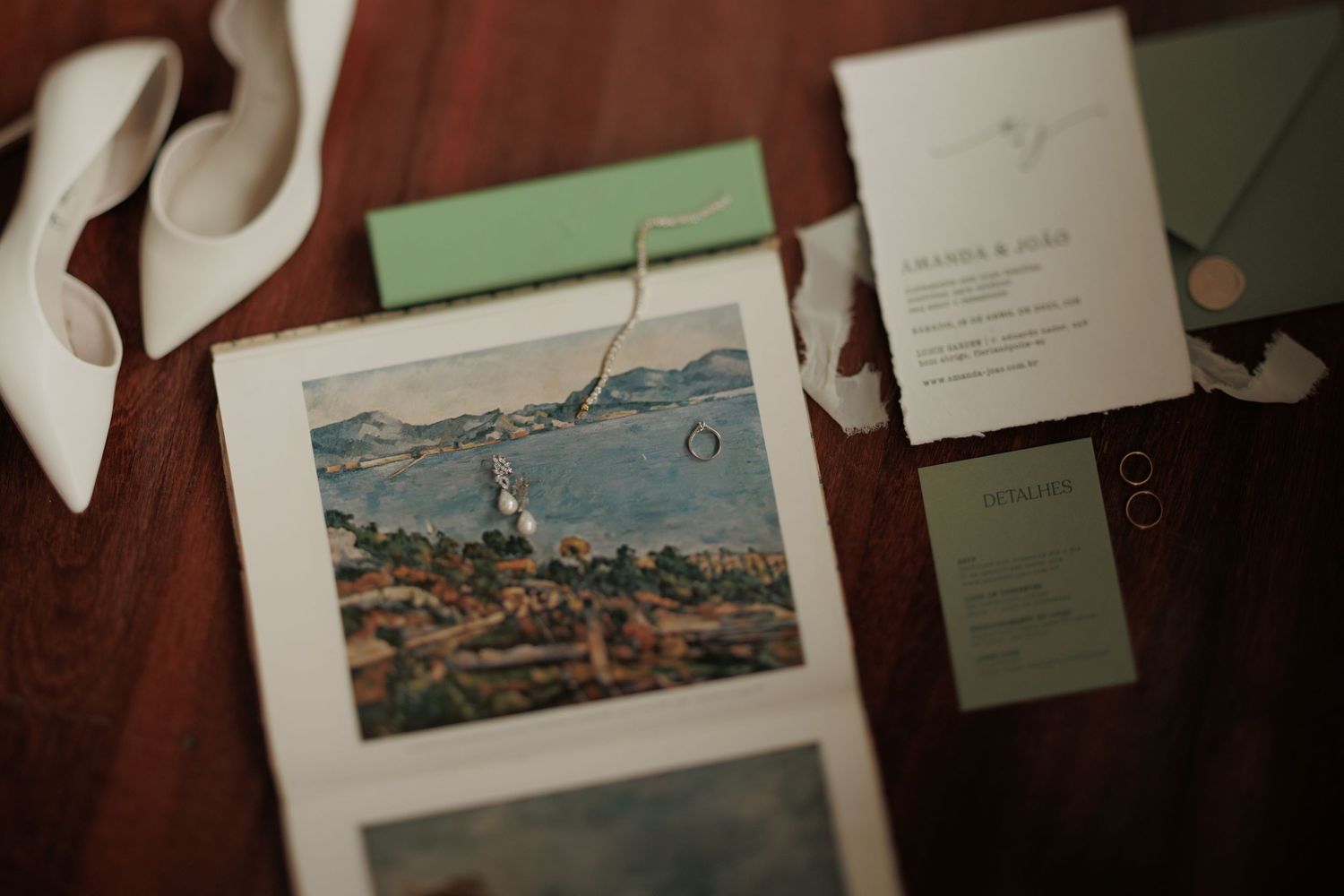 Wedding invitations and travel postcards arranged on a rustic brown wooden surface.