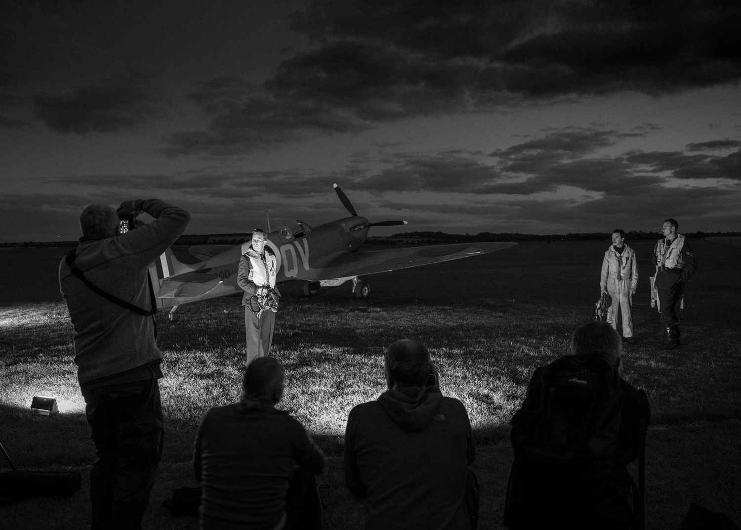 Night photography session featuring vintage aircraft with dramatic lighting and silhouetted figures.