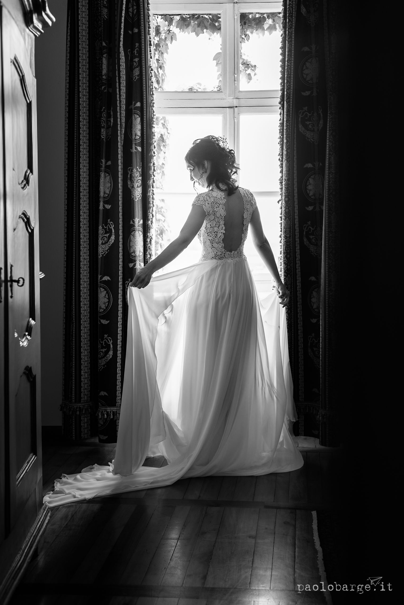 A bride in flowing white gown stands silhouetted against bright windows in a series of black and white photographs.